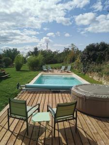 une piscine avec des chaises et un bain à remous dans l'établissement La bulle des champs, à Champmotteux