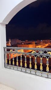 a balcony with a view of a city at night at Al Manafa Furnished Apartments in Salalah