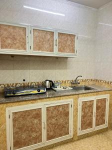 cocina con fregadero y encimera en Al Manafa Furnished Apartments, en Salalah