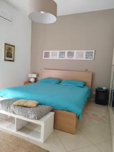 1 dormitorio con 1 cama con almohadas azules en casa Rituzza, en San Leone