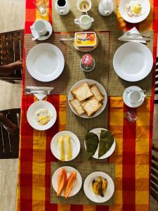 a table with white plates of food on it at Kandy Dilruk Homestay in Kandy