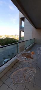 a balcony with two tables and a view of a building at Azul Aprumado in Peniche de Cima