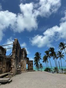 an old building on the beach with palm trees at Casa MARAGOGI com PISCINA e área GOURMET COMPLETA in Maragogi