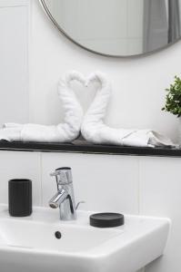 ein Waschbecken mit einem Spiegel und einem Handtuch in der Unterkunft Central MK 1 Bed Apartment With Parking in Buckinghamshire