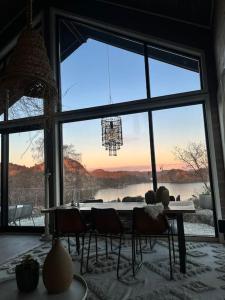 ファールスンにあるUnik hytte med fjordutsiktのテーブルと大きな窓のあるダイニングルーム
