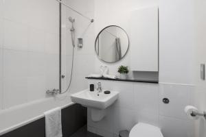 a white bathroom with a sink and a mirror at Central MK 1 Bed Apartment With Parking in Buckinghamshire