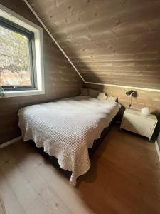 a bed in a small room with a window at Unik hytte med fjordutsikt in Farsund