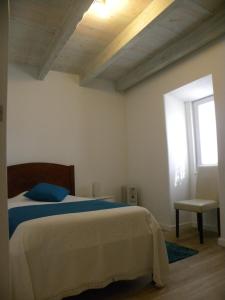 een slaapkamer met een bed en een raam bij Casa do Mar in Figueira da Foz
