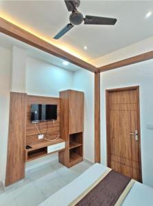 Schlafzimmer mit einem Bett, einem TV und einer Tür in der Unterkunft HOTEL HIVIN AND PEANCE - TOP RATED AND SERCH PROPERTY AMRITSAR in Amritsar