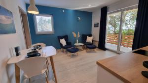 a living room with blue walls and a table and chairs at Apartments Suha Punta - Villa Babalonija in Kampor