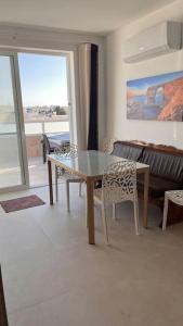 ein Wohnzimmer mit einem Tisch, Stühlen und einem Sofa in der Unterkunft Marsaxlokk 3 Bedroom Penthouse in Marsaxlokk