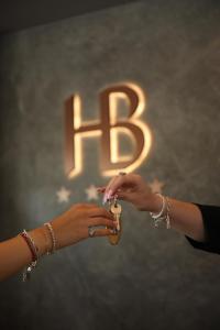 two women are holding a object with the letter b at Bel Sito Hotel Due Torri in Manocalzati