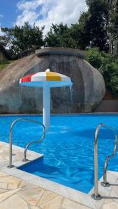 a colorful umbrella in the water next to a swimming pool at Hotel Campestre Atibaia in Atibaia