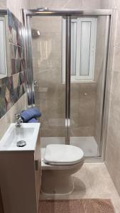 y baño con ducha, aseo y lavamanos. en Marsaxlokk 3 Bedroom Penthouse, en Marsaxlokk