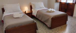 2 Betten in einem Hotelzimmer mit Handtüchern darauf in der Unterkunft Marilè in Carmiano