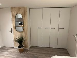 a bedroom with white cabinets and a mirror at Le zénith vieille ville d'Annecy in Annecy