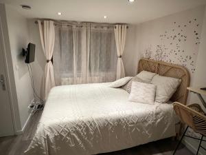 a bedroom with a bed with white sheets and a window at Le zénith vieille ville d'Annecy in Annecy