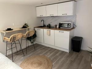 a small kitchen with white cabinets and a microwave at Le zénith vieille ville d'Annecy in Annecy