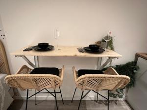 a dining room table with two chairs and a table with wine glasses at Le zénith vieille ville d'Annecy in Annecy
