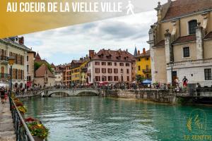 a river in a city with a bridge and buildings at Le zénith vieille ville d'Annecy in Annecy +19 photos