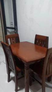 a wooden table with two chairs around it at Nador Apartment in Nador