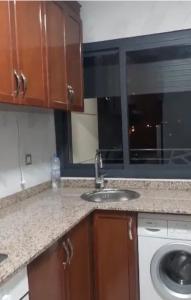 um balcão de cozinha com um lavatório e uma janela em Nador Apartment em Nador