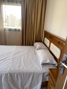 um pequeno quarto com uma cama e uma janela em Nador Apartment em Nador