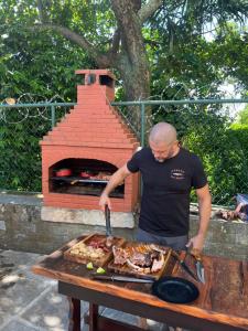 un uomo che prepara il cibo su un tavolo con un forno di mattoni di Castelo dos Tucanos Hostel a Rio de Janeiro