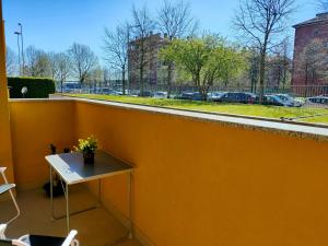 a yellow wall with a table and flowers on it at Curiel in Rozzano