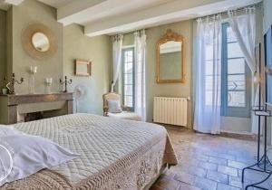 a bedroom with a large bed and a fireplace at Le Gardien des Anges in Vers Pont du Gard
