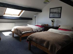 a bedroom with two beds and a window at Kingfisher Cottage in High Bentham