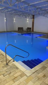 a large pool with blue water in a building at Hotel Campestre Atibaia in Atibaia