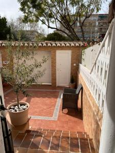a patio with a potted tree and a white fence at Como en casa! in Alfafar
