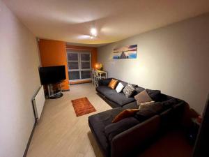 a living room with a couch and a flat screen tv at Aberdeen Beach 2 Bed Apartment in Aberdeen