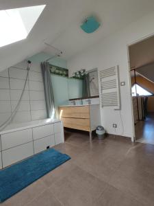 La salle de bains est pourvue d'une baignoire, d'un lavabo et d'un miroir. dans l'établissement La Soranaise, chambre chez habitant à la campagne, à Sorans-lès-Breurey