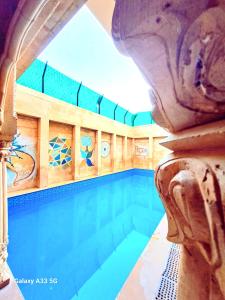 a large swimming pool in a building with a large sqor at Hotel Tokyo Palace in Jaisalmer