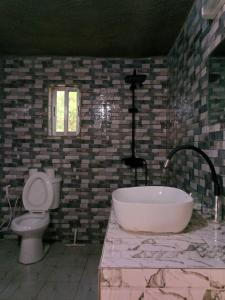 a bathroom with a bath tub and a toilet at Poco Loco B&B in Abene