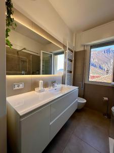 ein Badezimmer mit einem Waschbecken, einem WC und einem Spiegel in der Unterkunft Buddy'S House in Abbadia Lariana
