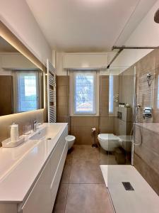 ein Badezimmer mit zwei Waschbecken, einem WC und einer Dusche in der Unterkunft Buddy'S House in Abbadia Lariana