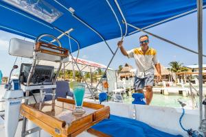 a man standing on the bow of a boat at Walk barefoot to beach! Private Sailboat at North End, queen bed, en-suite bath, AC in Isla Mujeres