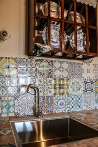 una cucina con lavandino e piastrelle sul muro di IL MAGNIFICO a Montepulciano Altre 32 foto