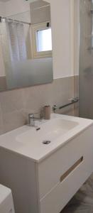 La salle de bains est pourvue d'un lavabo blanc et d'un miroir. dans l'établissement Marilè, à Carmiano