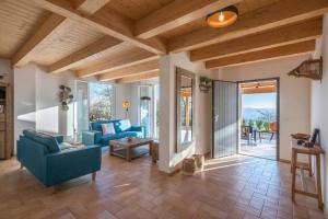 una sala de estar con sofás azules y techo de madera. en Villa Il Sole Marcheholiday, en SantʼAngelo in Pontano