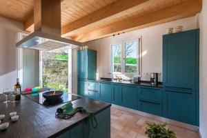 una cocina con armarios azules y fregadero en Villa Il Sole Marcheholiday, en SantʼAngelo in Pontano
