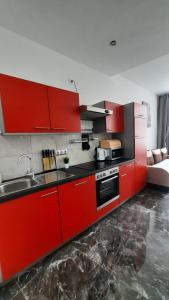 a kitchen with red cabinets and a sink at Studio u Arka in Kłodzko