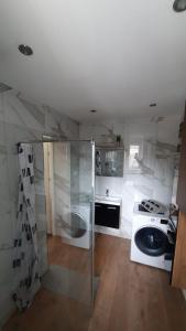 a white kitchen with a stove and a sink at Studio u Arka in Kłodzko