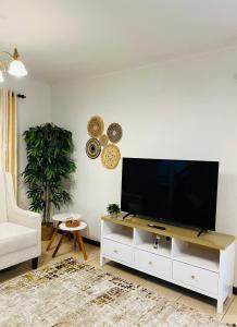 una sala de estar con TV de pantalla plana en un armario blanco en Peaceful and Cozy Home in Arusha, en Ngateu