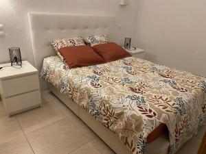 ein Schlafzimmer mit einem Bett und zwei Nachttischen in der Unterkunft Ana Sun in Albufeira