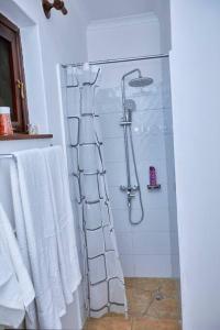 a shower in a bathroom with white towels at Peaceful and Cozy Home in Arusha in Ngateu