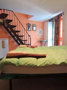 a bed in a room with a spiral staircase at Etnalcantara16 in Castiglione di Sicilia